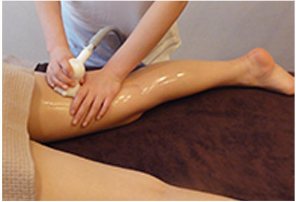 다리에 작은 둥근 장비로 순환 관리를 하는 장면