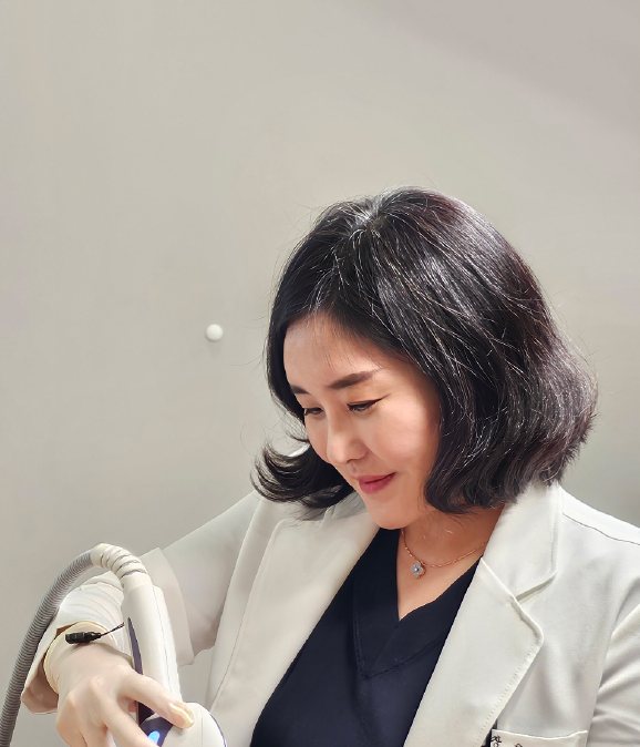 강은희 원장 — 흰 가운 차림으로 장비를 들고 시술하는 모습