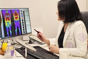 흰 가운 의료진이 체열 사진 모니터를 짚으며 분석하는 장면